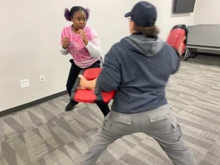 Student practicing self-defense training during the Macon Campus R.A.D. course..